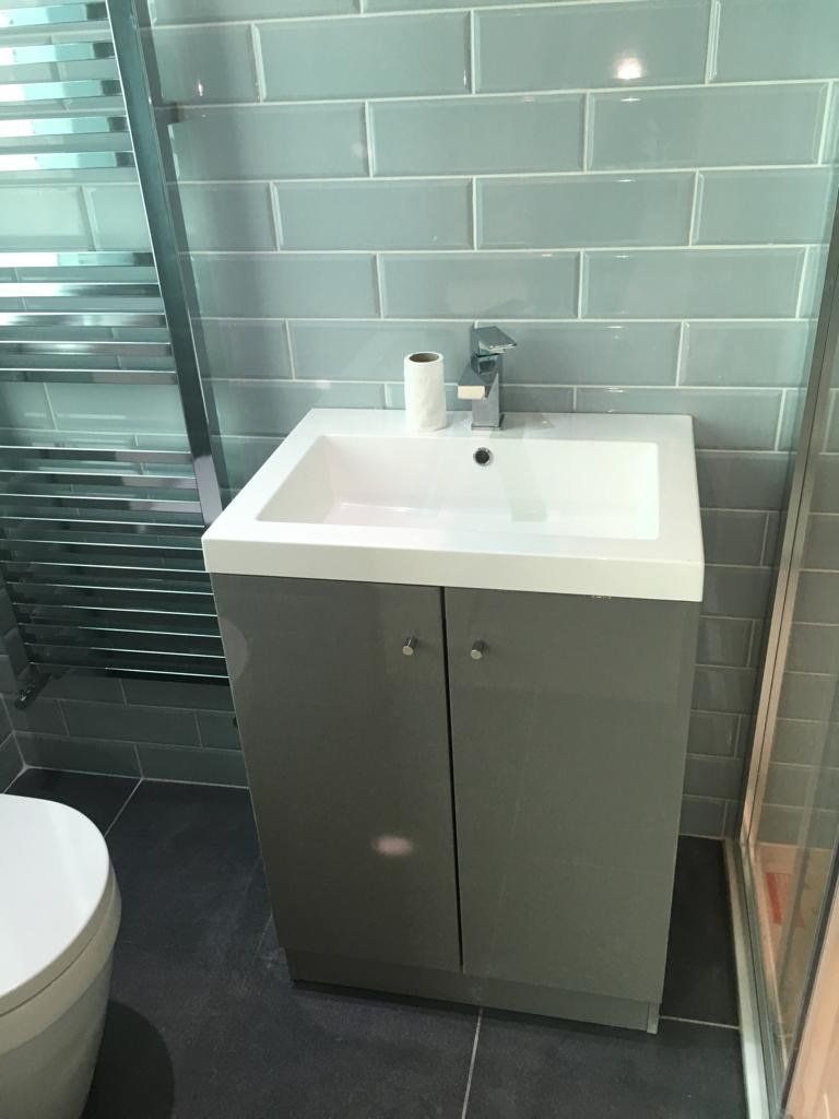 A bathroom with a sink , toilet and towel rack.
