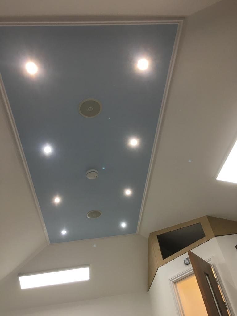 A blue ceiling with a lot of lights on it in a room.