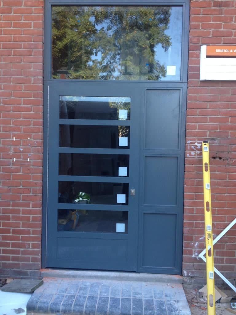 A brick building with a gray door and a yellow level