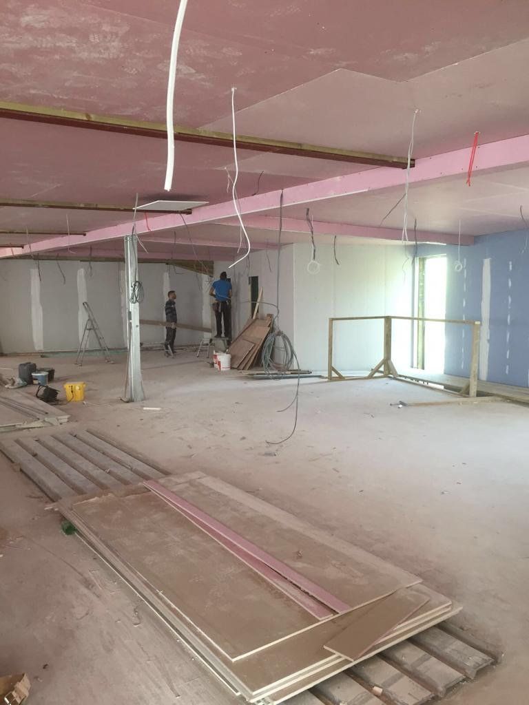 A large room with a pink ceiling is being remodeled.