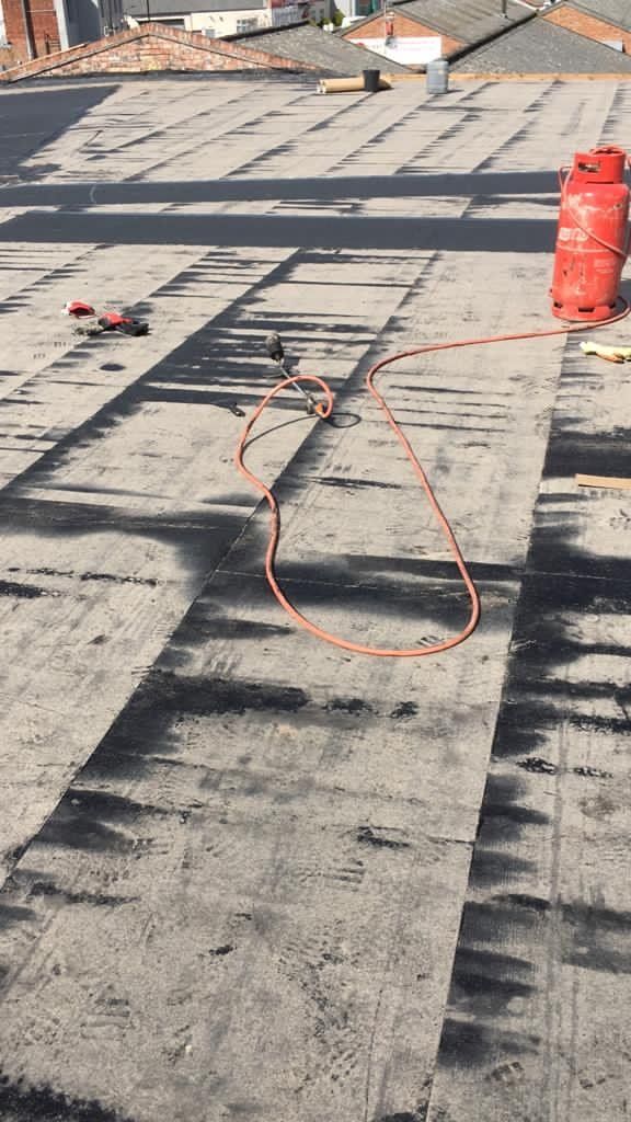 A roof with a gas cylinder and a hose on it.