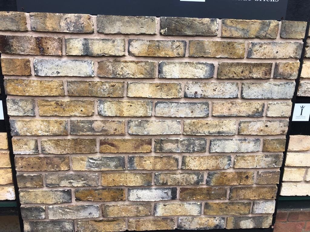 A close up of a brick wall with a sign in the background.