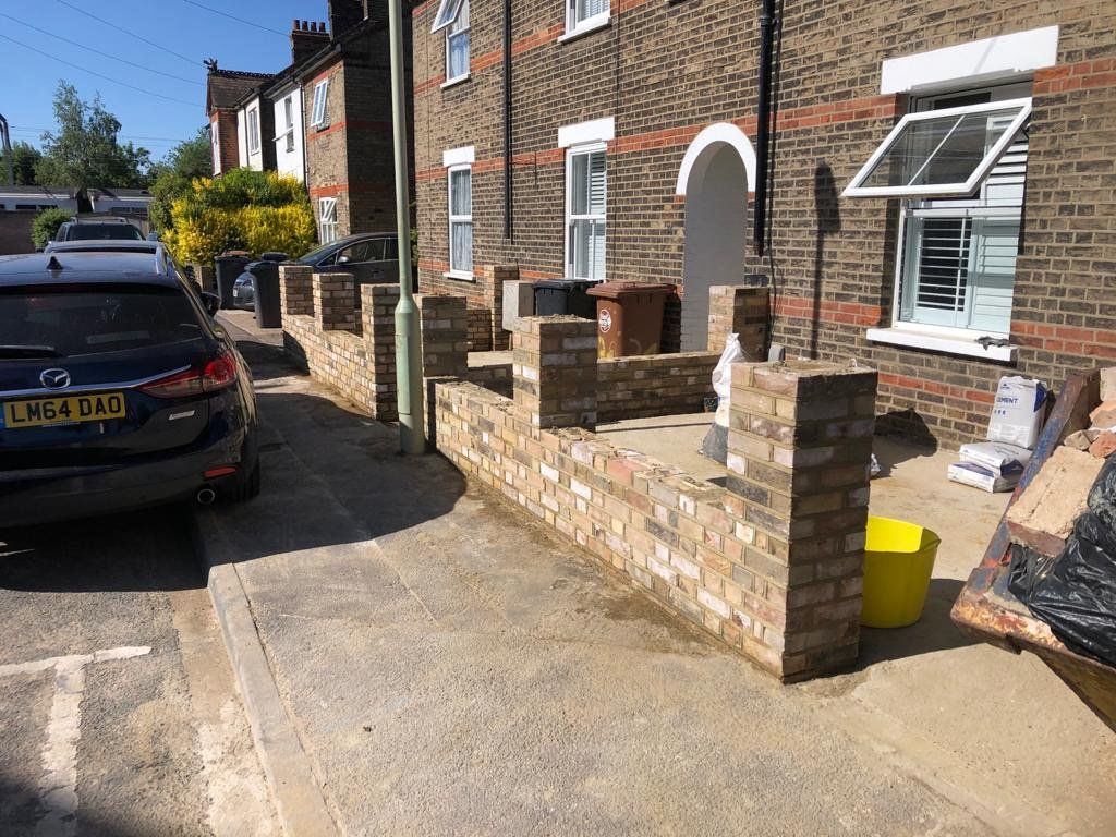 A car is parked in front of a brick building.