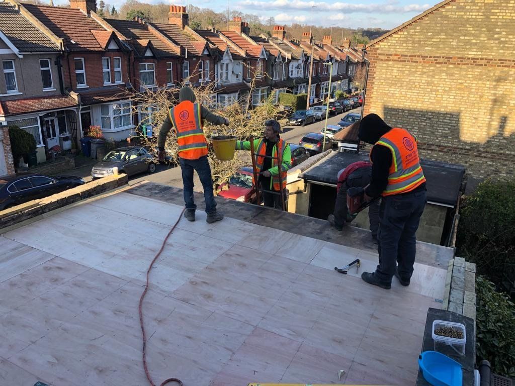 A group of construction workers are working on a roof.