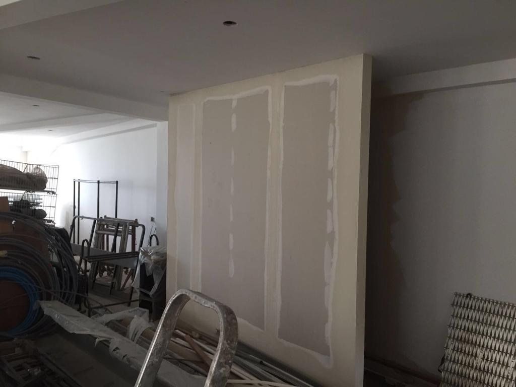 A ladder is sitting next to a wall in a room.