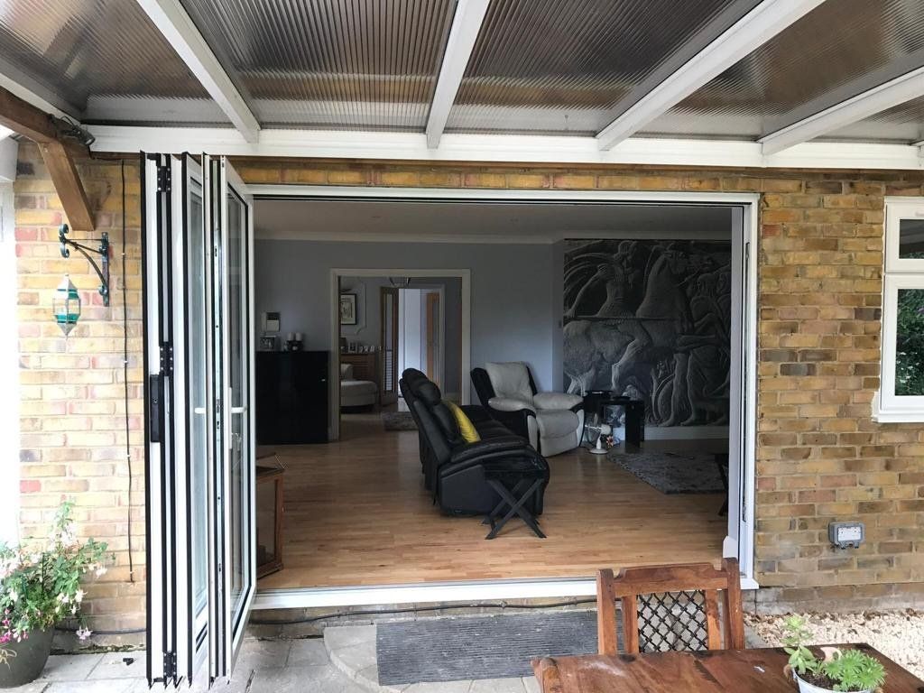 A living room with a table and chairs and a sliding glass door.
