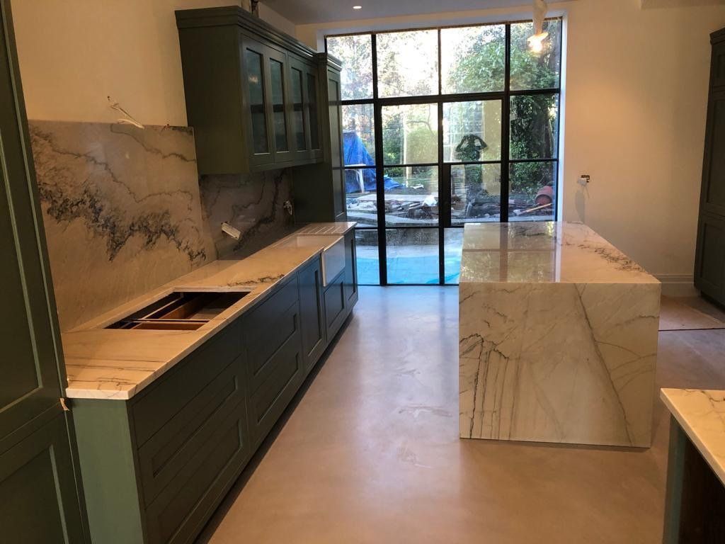 A kitchen with a large island in the middle and a large window.