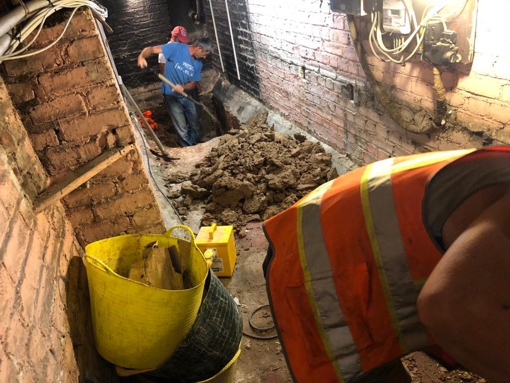 A man is digging a hole in a brick wall.