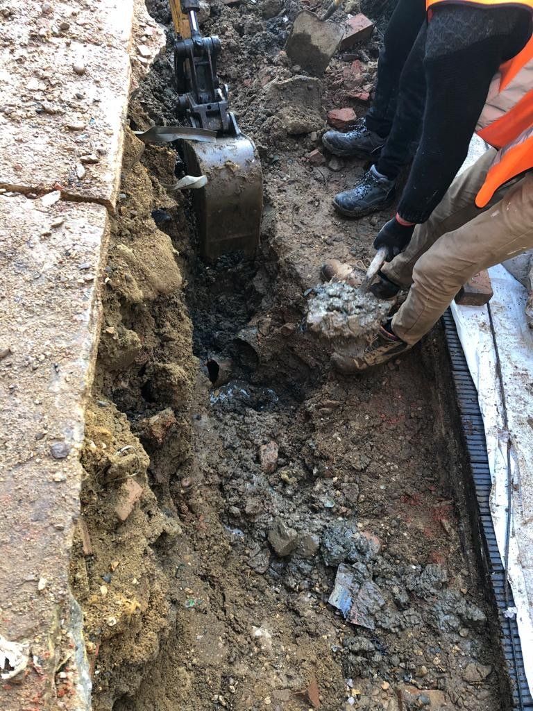 A group of construction workers are digging a hole in the ground.
