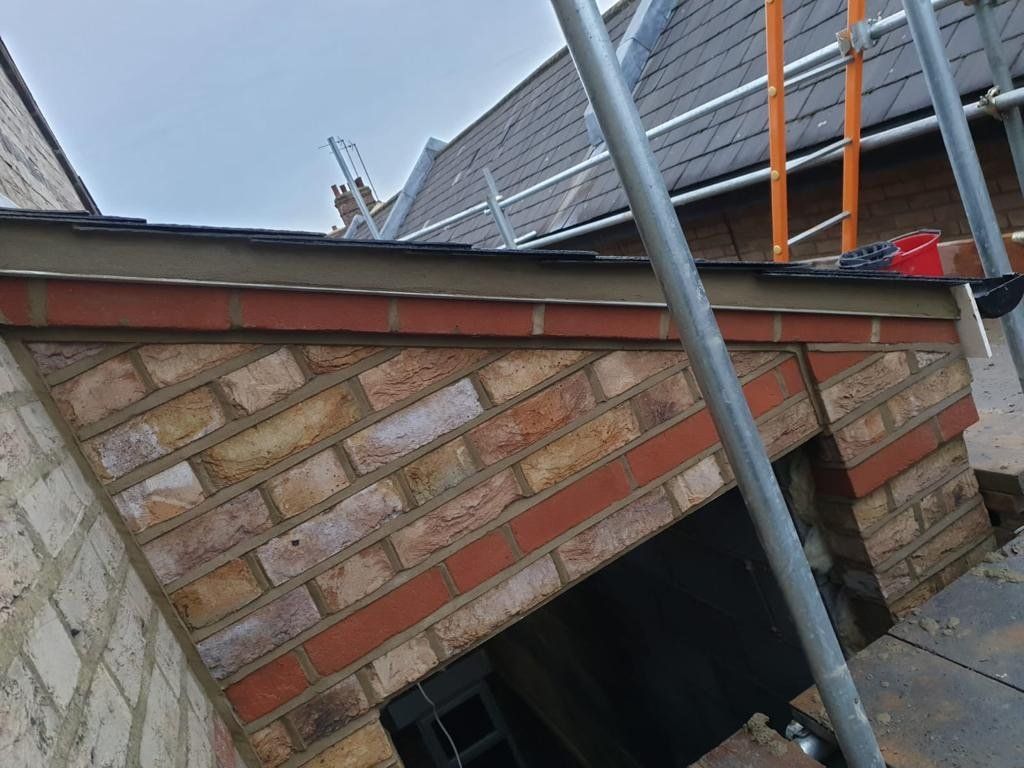 A brick wall is being built on the side of a building.