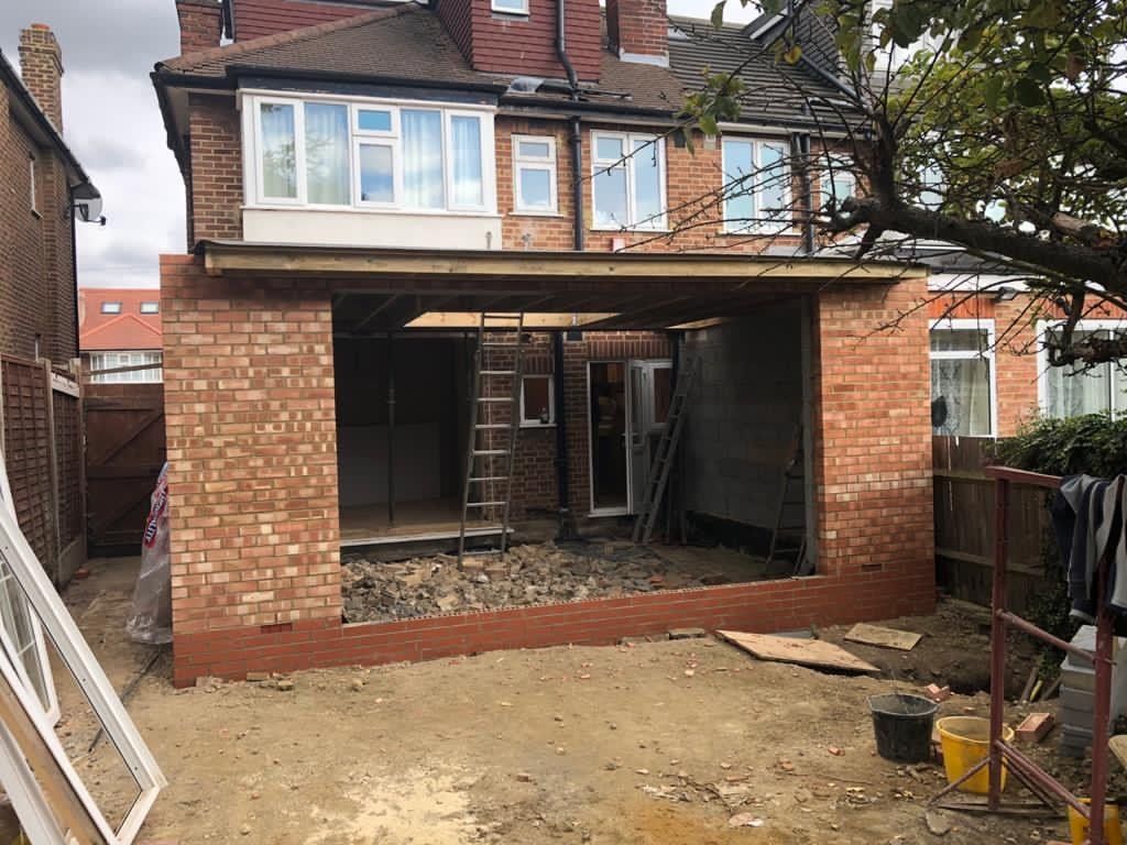 A brick house is being remodeled with a sliding glass door.