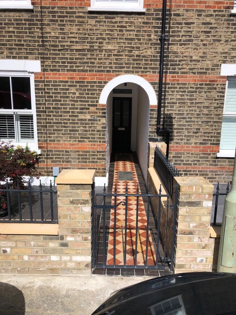 A brick house with a black car parked in front of it
