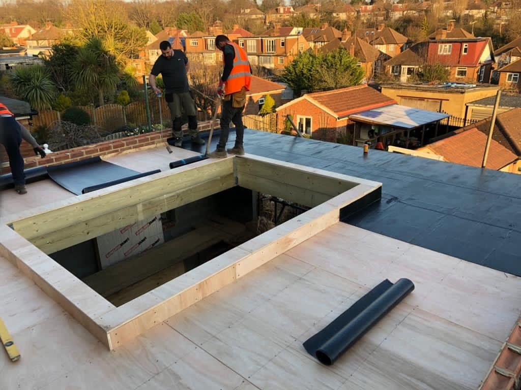 A group of construction workers are working on a roof