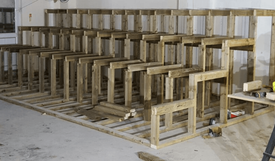 A row of wooden stairs are being built in a room.