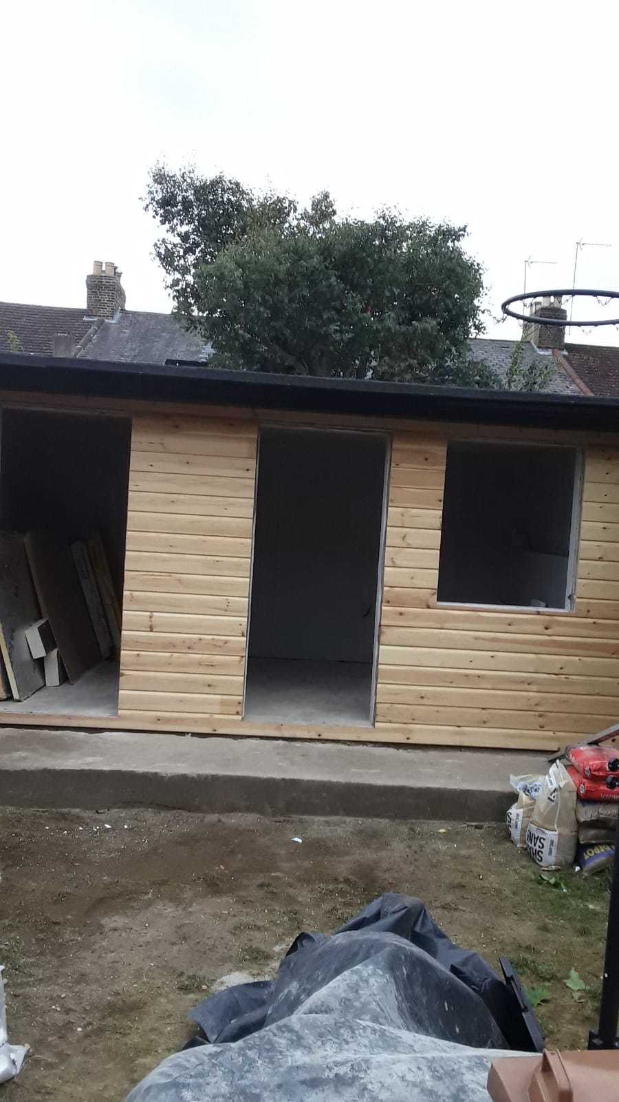A wooden shed is being built in a backyard.