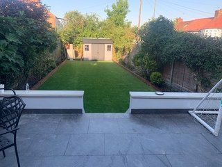 A backyard with a large lawn and a shed.