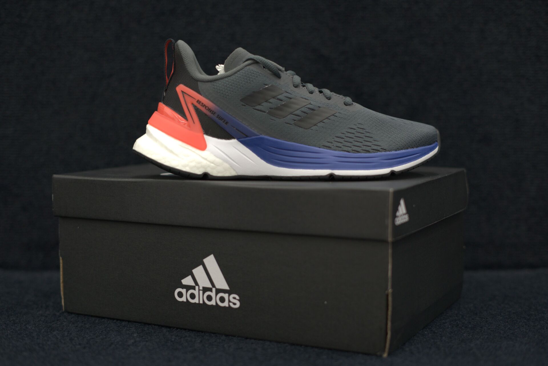 A pair of adidas shoes sitting on top of a black box