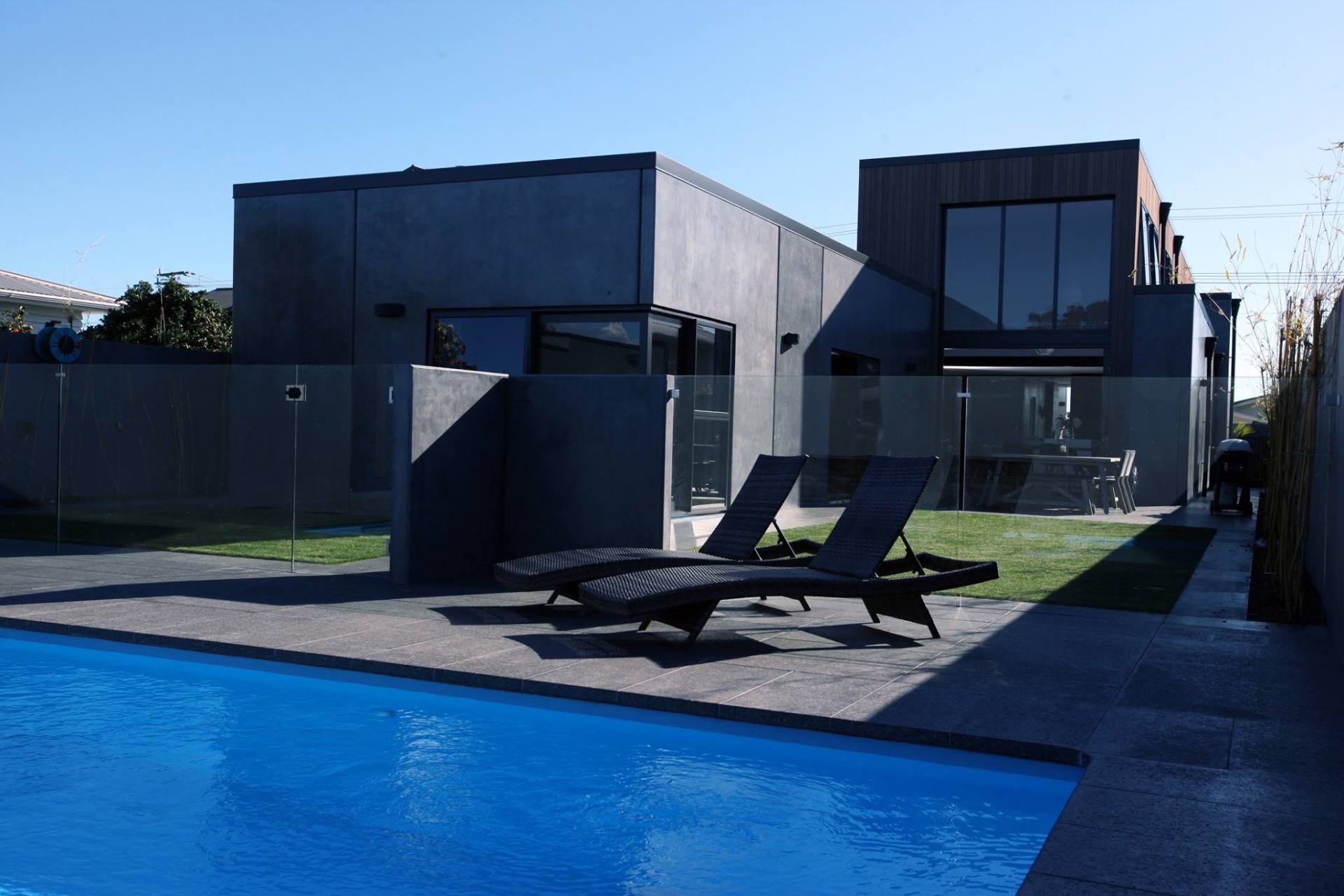 A large swimming pool in front of a house