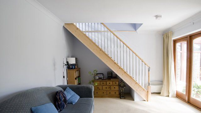 A living room with a couch and stairs leading up to the second floor