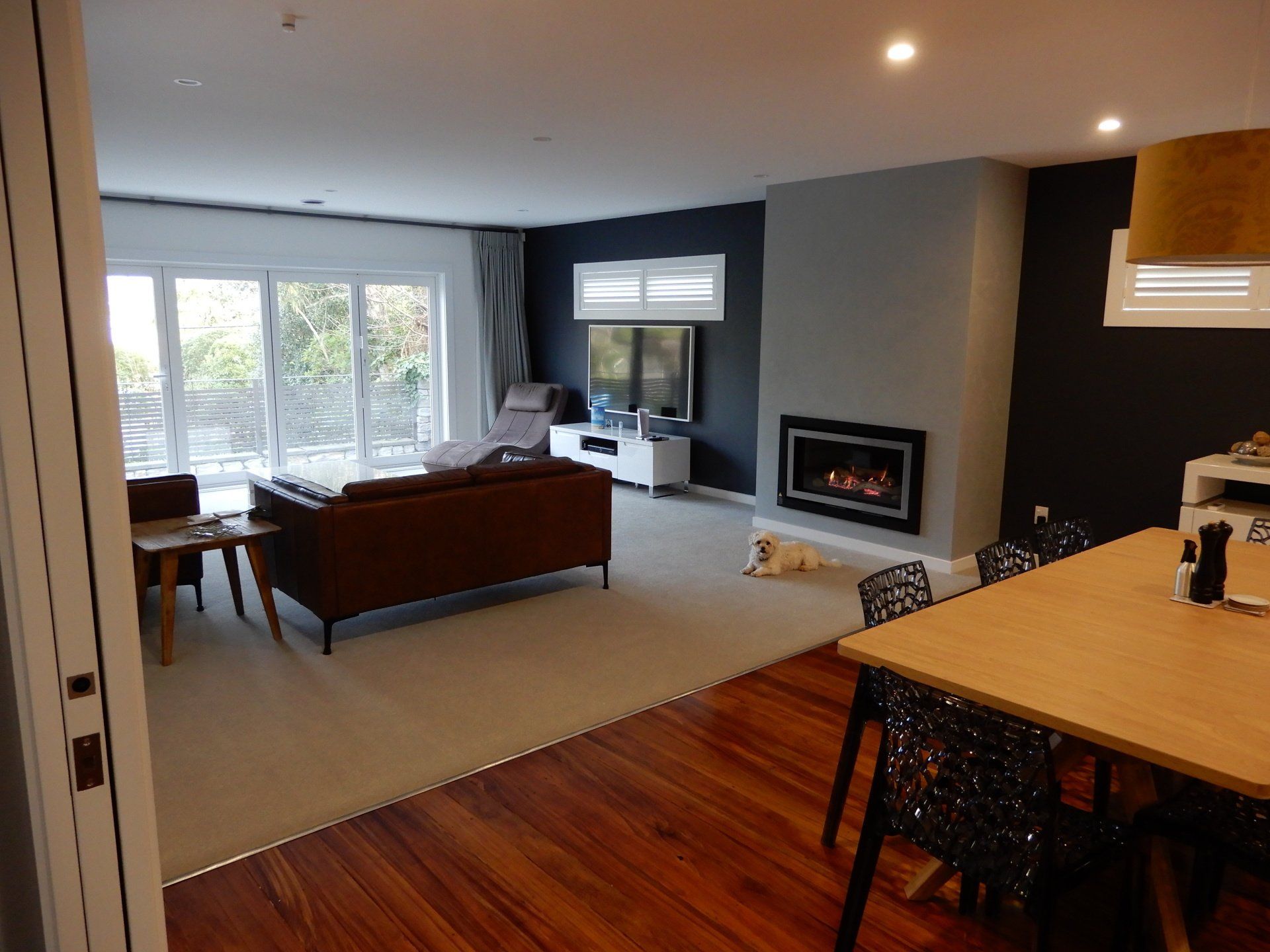 A living room with a couch , table , chairs and a fireplace.