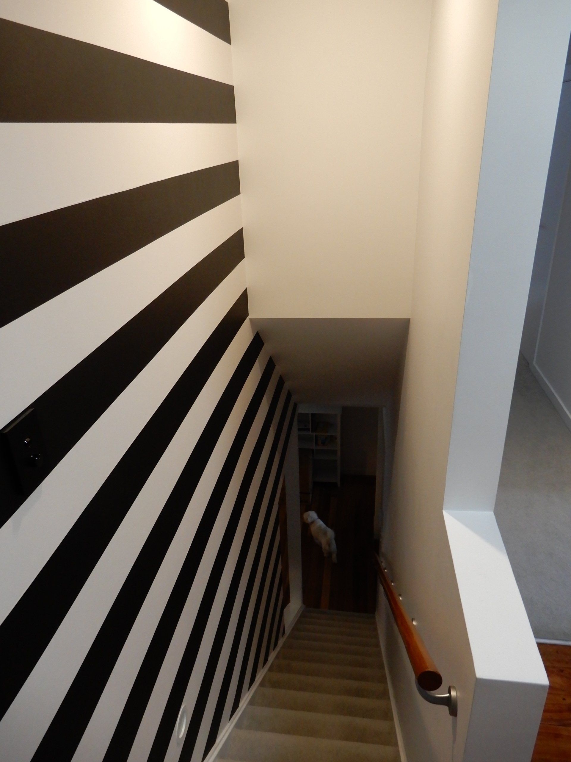 A staircase with black and white stripes on the wall