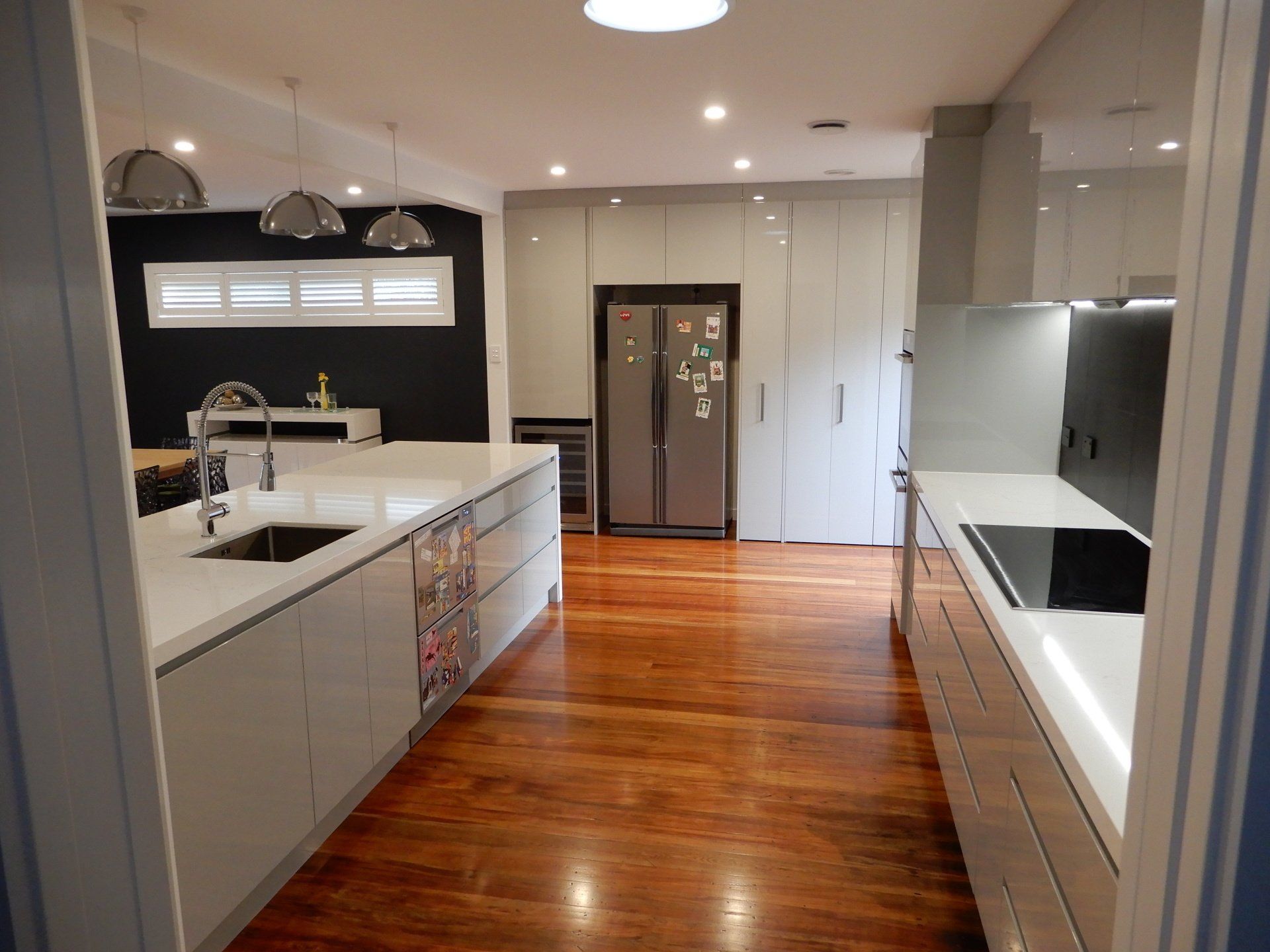 A kitchen with white cabinets and a stainless steel refrigerator