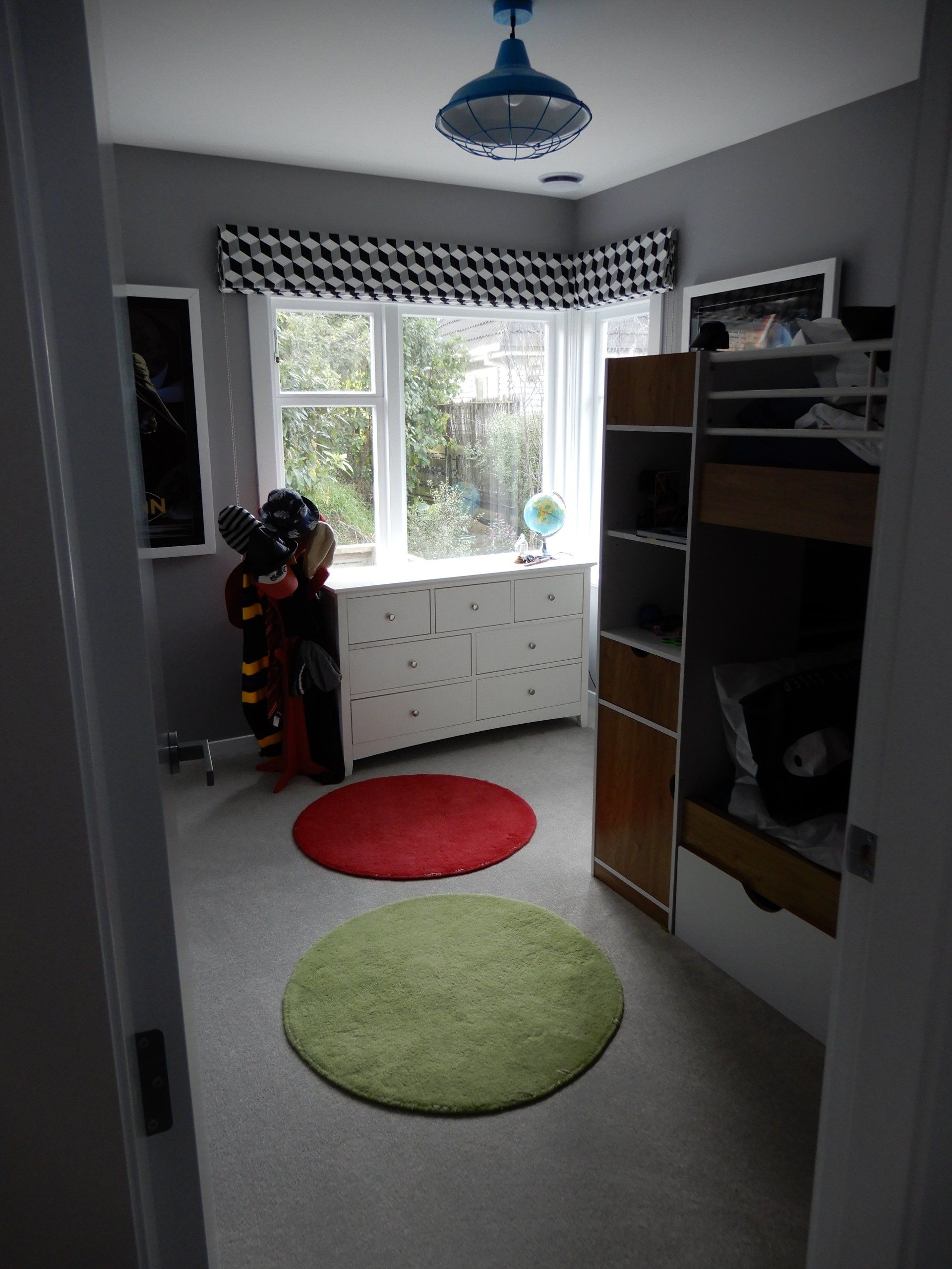 A room with a green rug and a red rug