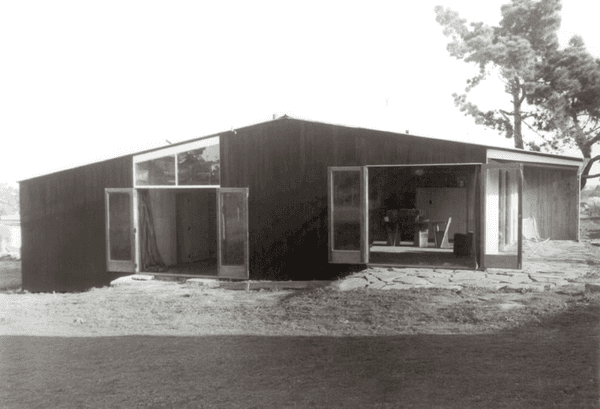 A black and white photo of a house with a lot of windows