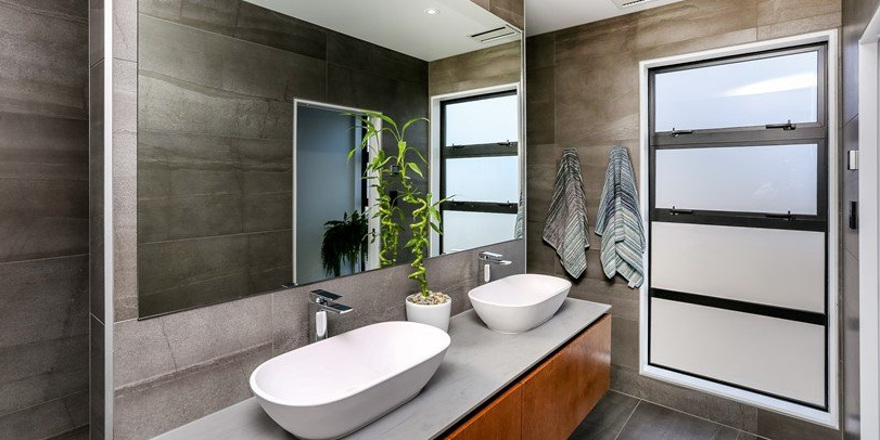 A bathroom with two sinks and a large mirror.