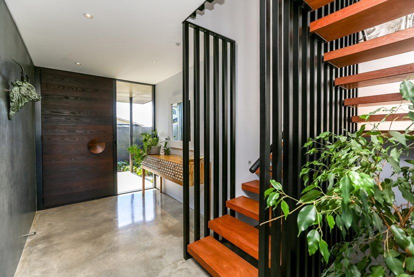A hallway with stairs leading up to the second floor of a house.