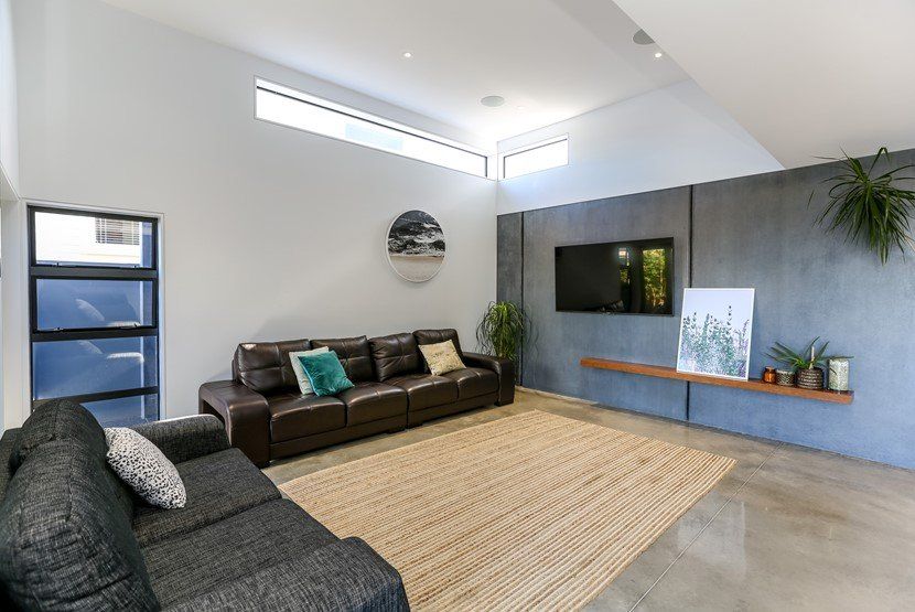 A living room with a couch , rug and television.