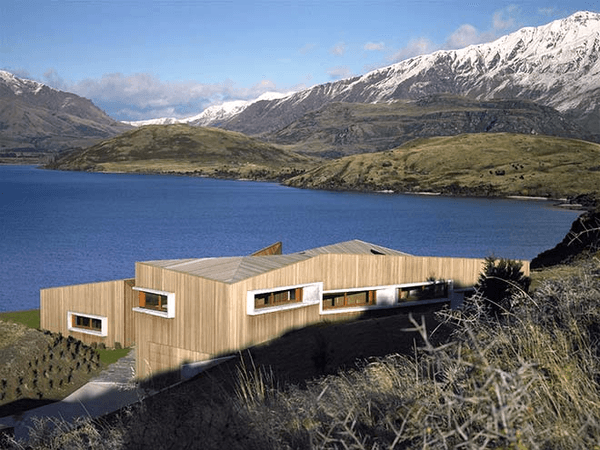 A house with a lake and mountains in the background