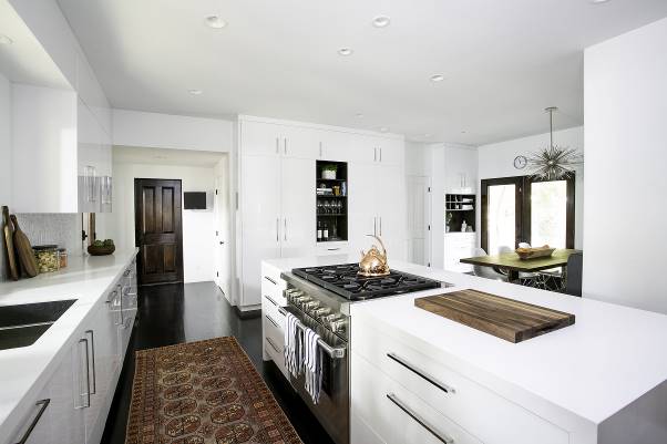 A kitchen with white cabinets and stainless steel appliances