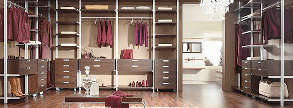 A walk in closet with lots of shelves and drawers
