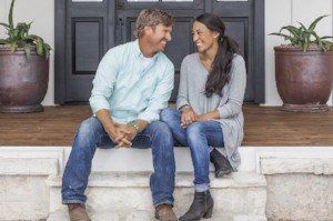 A man and a woman are sitting on the steps of a house.