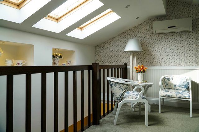 A room with a table and chairs and a skylight