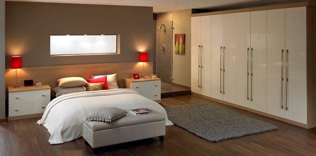 A bedroom with a bed , nightstands , cabinets and a rug