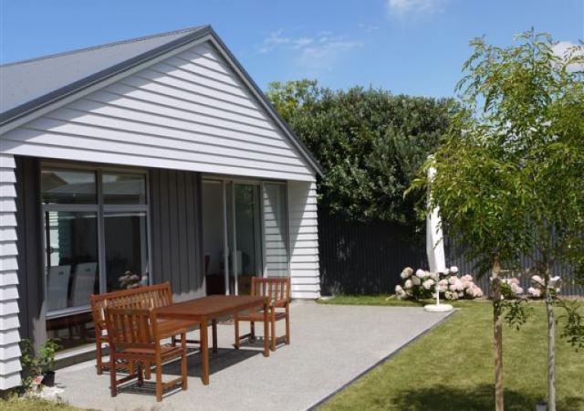 A house with a table and chairs in front of it