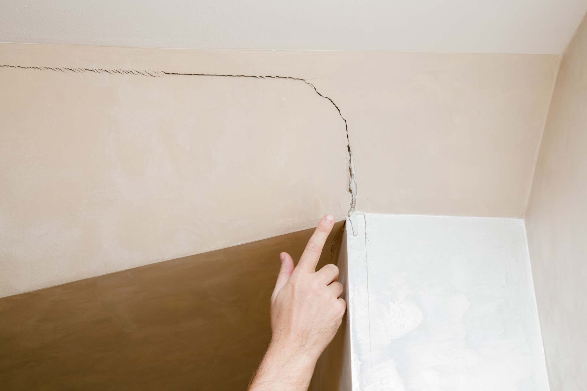 Man's Hand Finger Pointing To The Cracked Wall In A House - Pest Control in Mudgee NSW