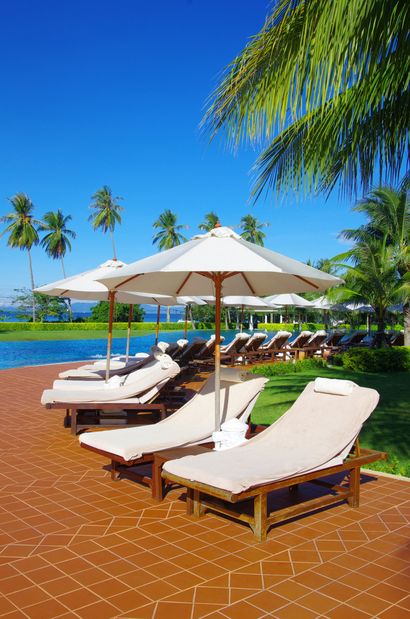 lounge chairs by the pool palm trees and nice tile