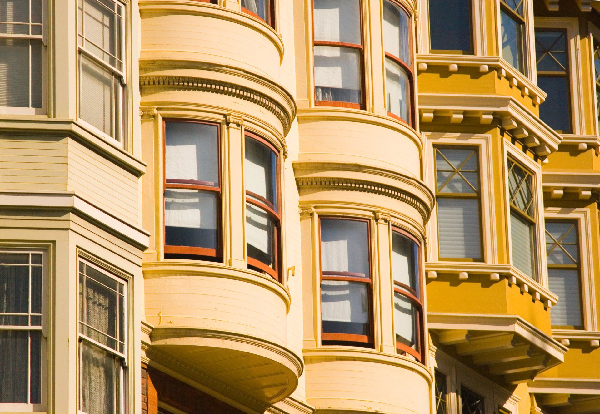 A row of yellow buildings with lots of windows
