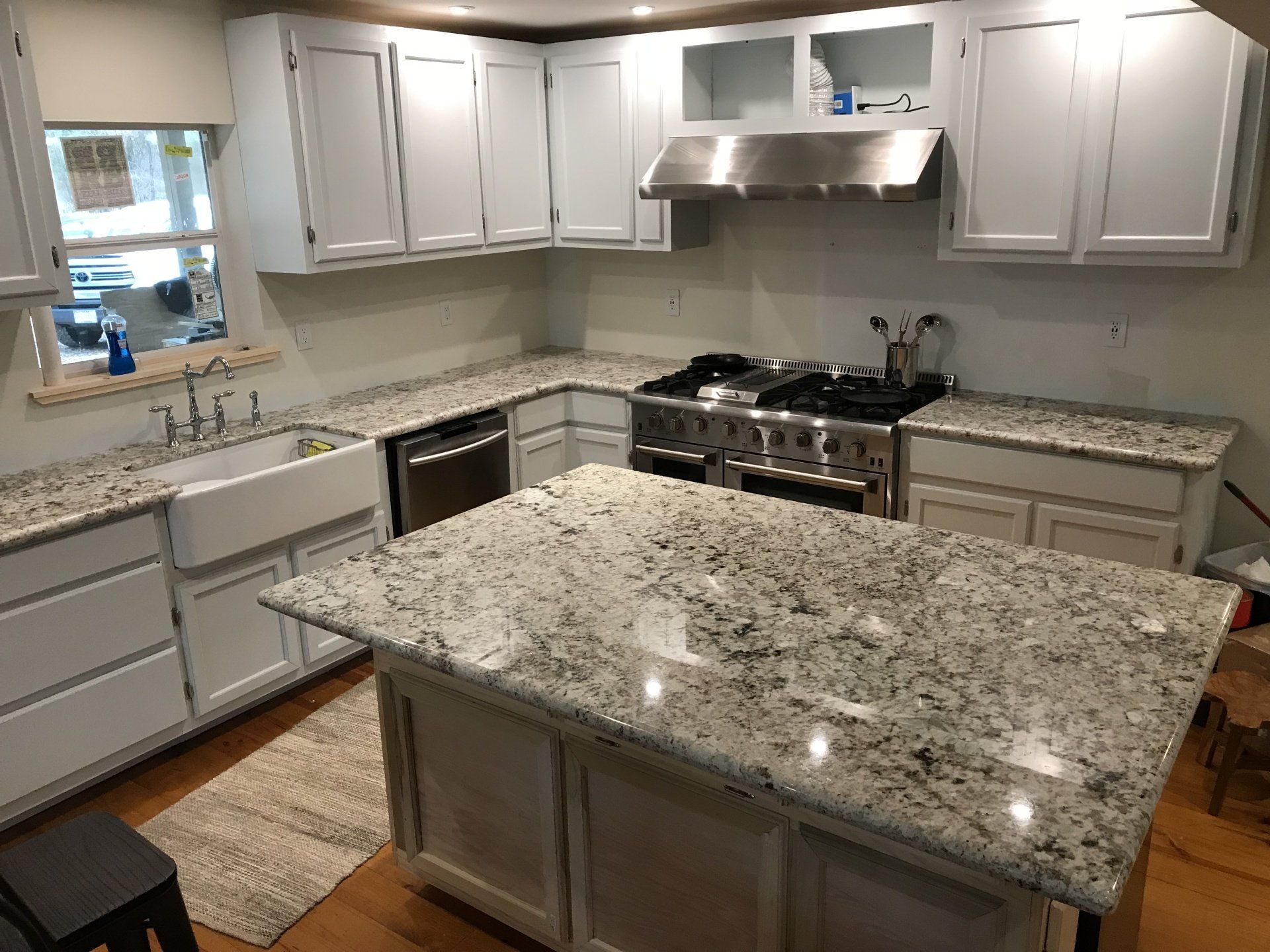 Bright modern kitchen with white cabinets, granite counters, and a large island.