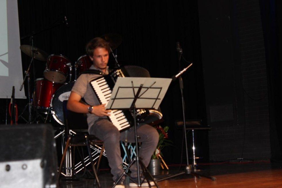 Ragazzo che suona la fisarmonica con l'ausilio di uno spartito