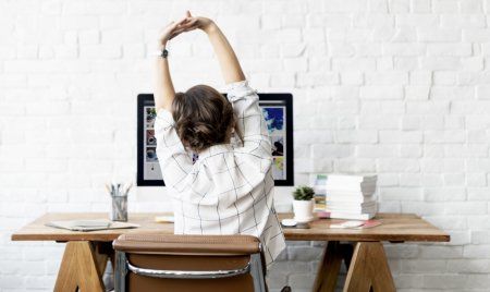 person stretching arms at desk