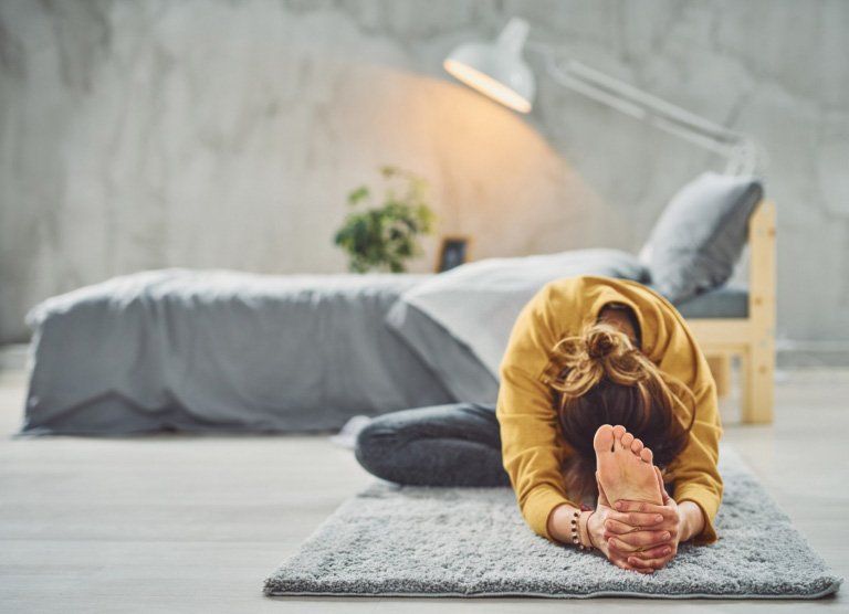 person doing yoga on soft mat