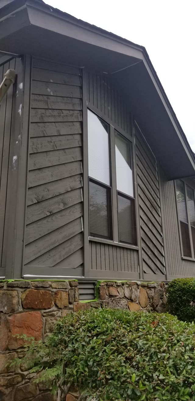 A house with a lot of windows and a stone wall.