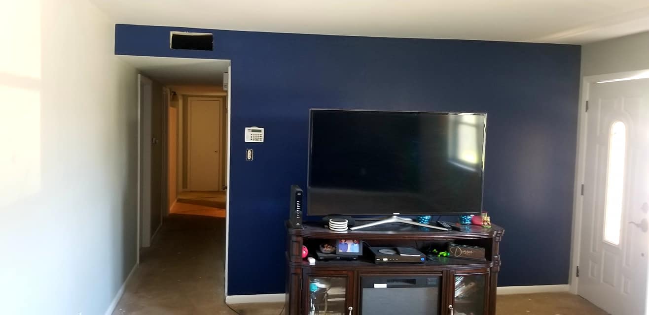 A living room with blue walls and a flat screen tv