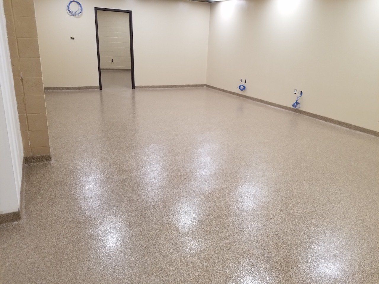 A large room with a shiny floor and white walls.