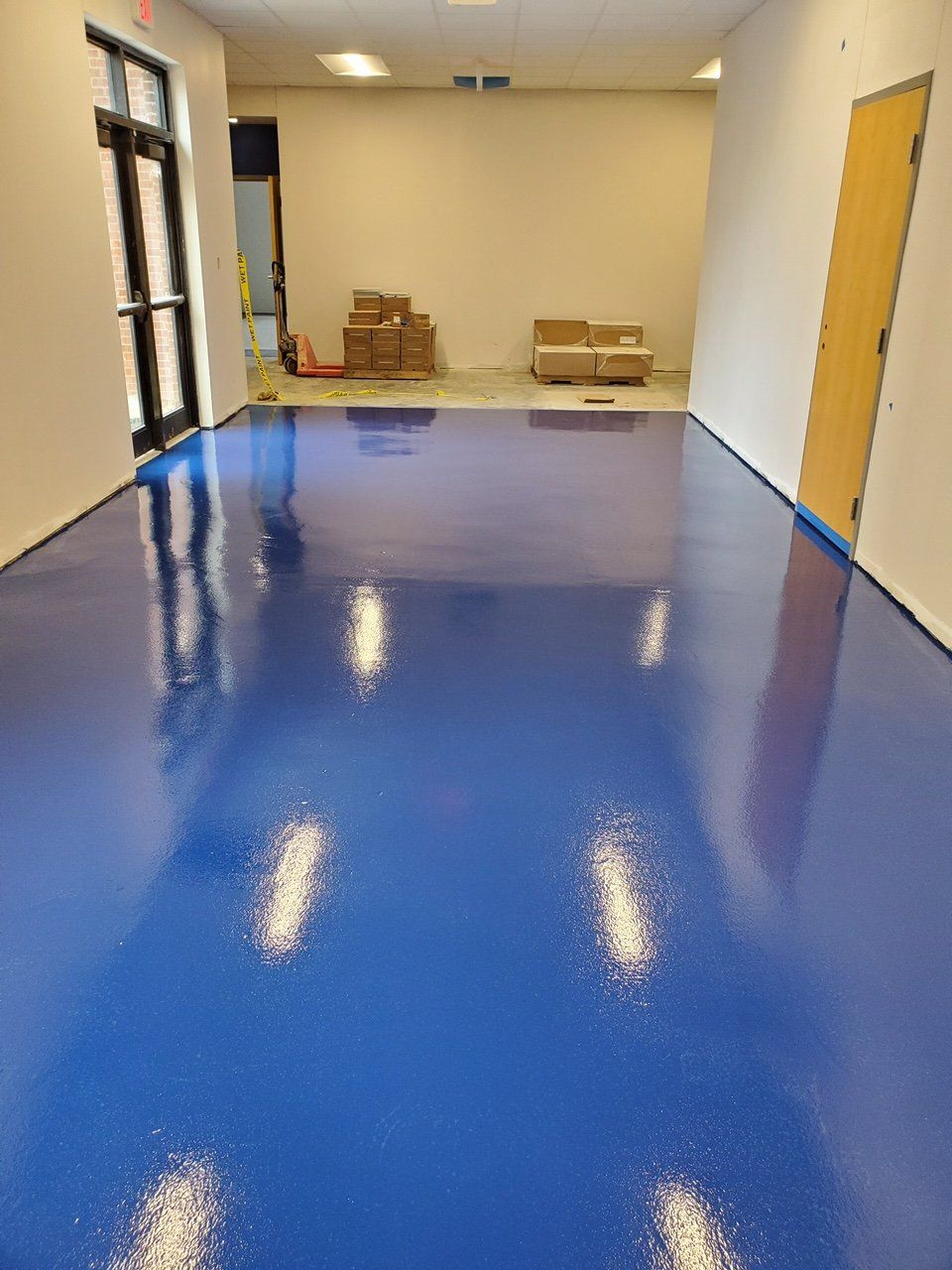 A large room with a blue floor and white walls.