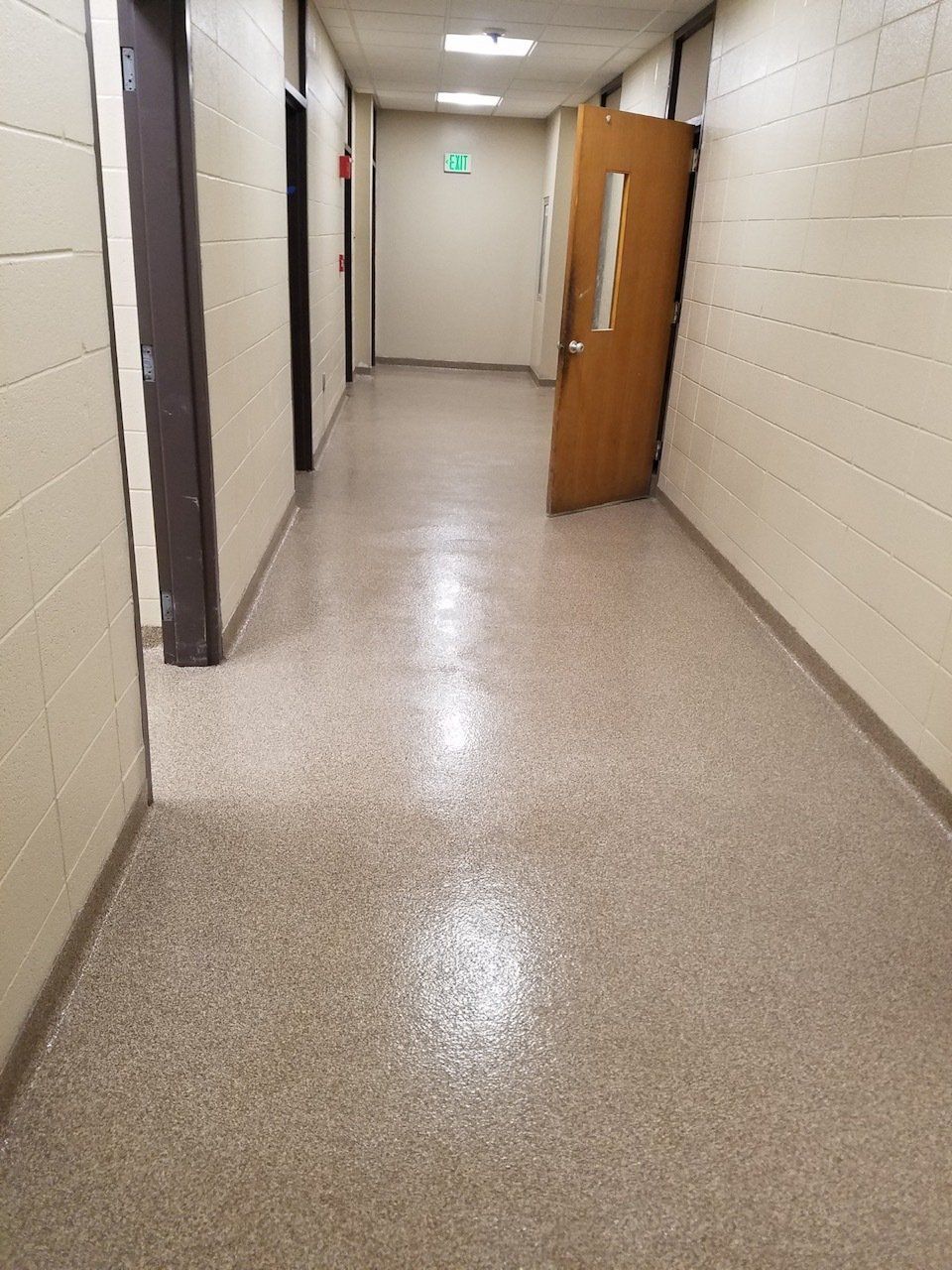 A long hallway with a door in the middle of it.